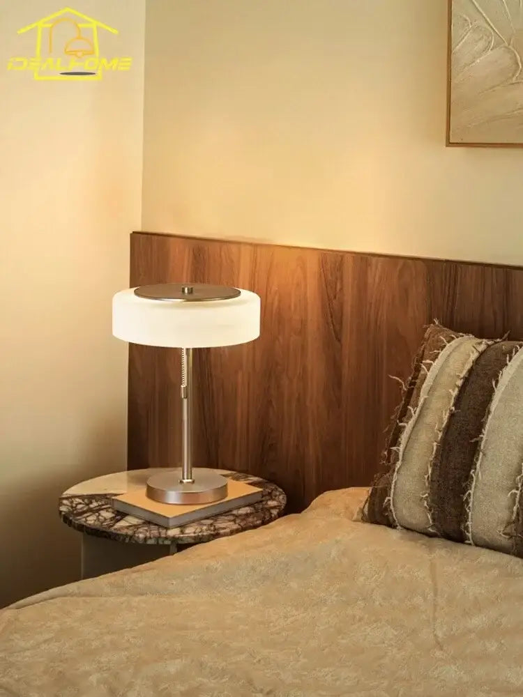 Modern cream glass table lamp with a sleek silver metal base and frosted white cylindrical shade for bedroom decorbites cream glass