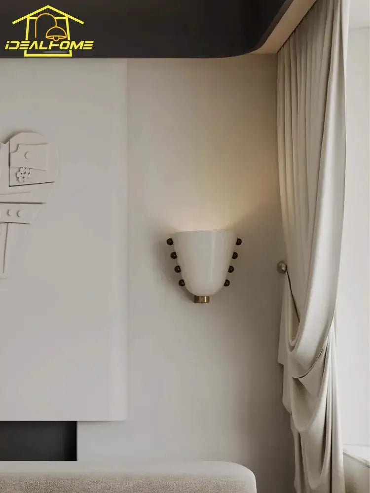 Modern cream glass wall lamp with cream-colored ceramic bowl design and dark brown spherical accents for bedroom decorbites cream glass