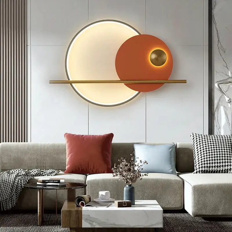 Modern cream and orange circular led wall lamp with warm glow and gold-toned metal trim for bedroom lighting