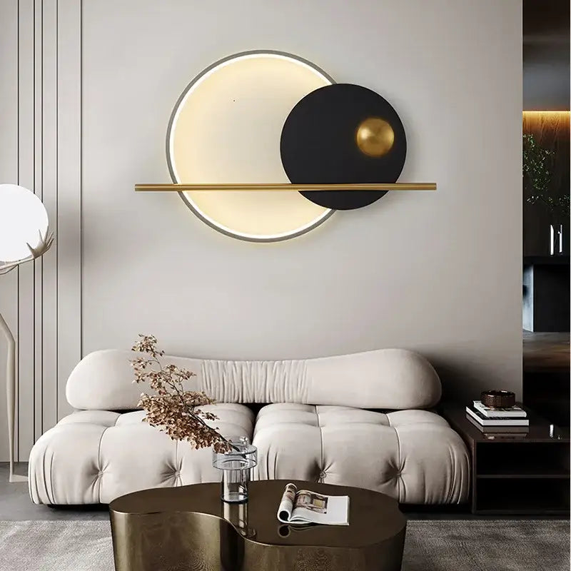 Modern cream and orange circular led wall lamp with glowing inner circle black disc gold sphere and brass bar for bedroom lighting