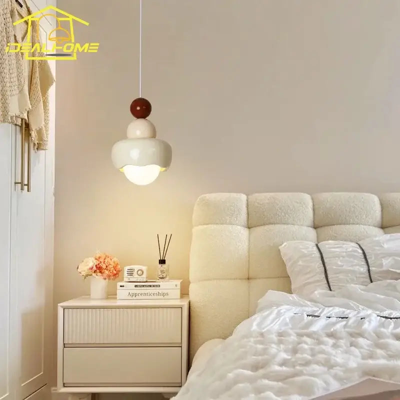 A modern pendant light with a tiered matte white and warm brown resin design for decorbites cream bedroom decor
