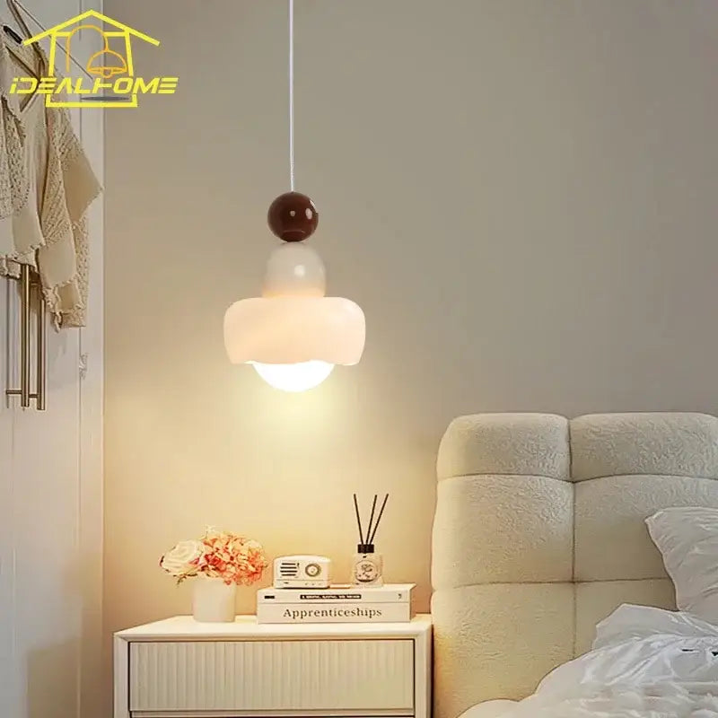 A modern pendant light with a frosted glass shade and dark brown top for decorbites cream bedroom decor