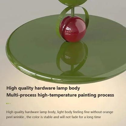 A glossy red spherical lamp bulb on an olive green base with metallic accent in modern cream iron nordic ceiling light