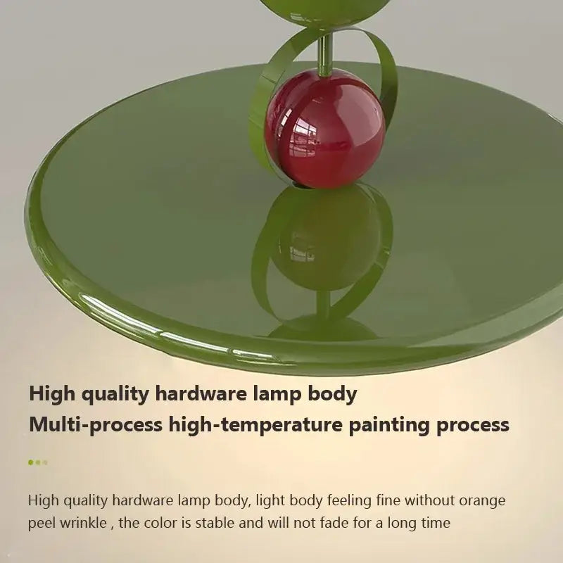 A glossy red spherical lamp bulb on an olive green base with metallic accent in modern cream iron nordic ceiling light
