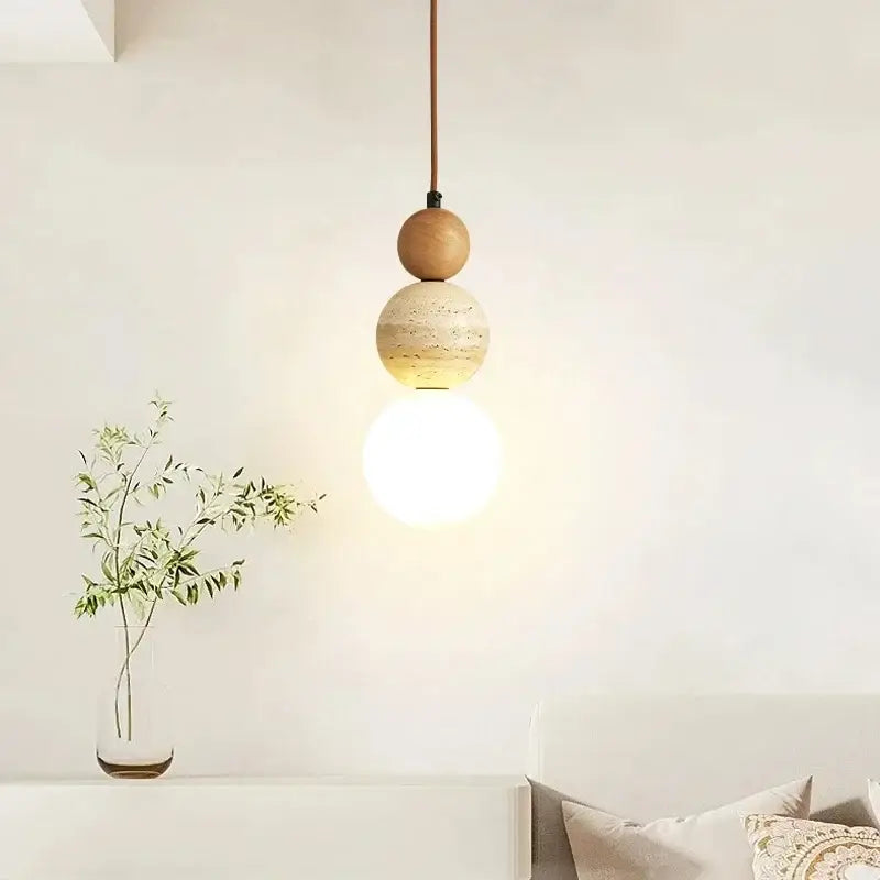Minimalist pendant light with cream stone and wood accent featuring stacked spheres, ideal for dining room lighting