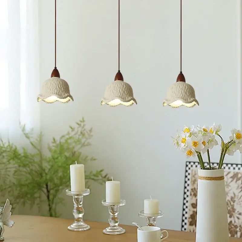 Three cream bud micro cement pendant lamps with textured glass and scalloped edges hang in a row for bedroom decorbites bud micro decor