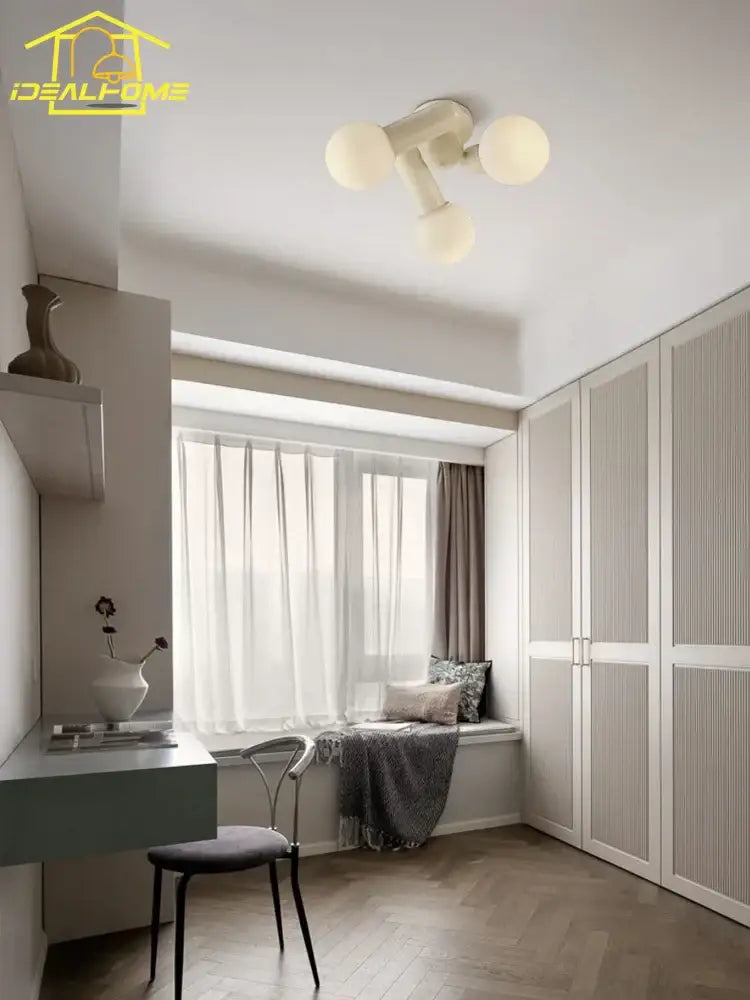 Off-white cream wind led ceiling light with three frosted glass globe bulbs in a modern minimalist bedroom design