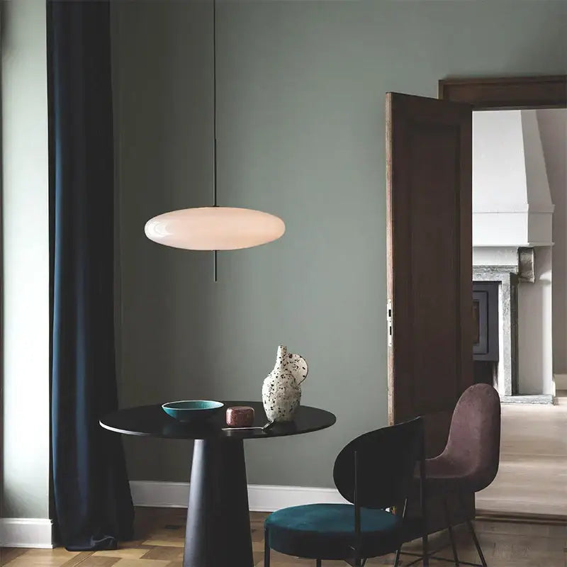 A modern creative black iron pendant light with an off-white oval glass shade for bar and restaurant decorbites iron pendant