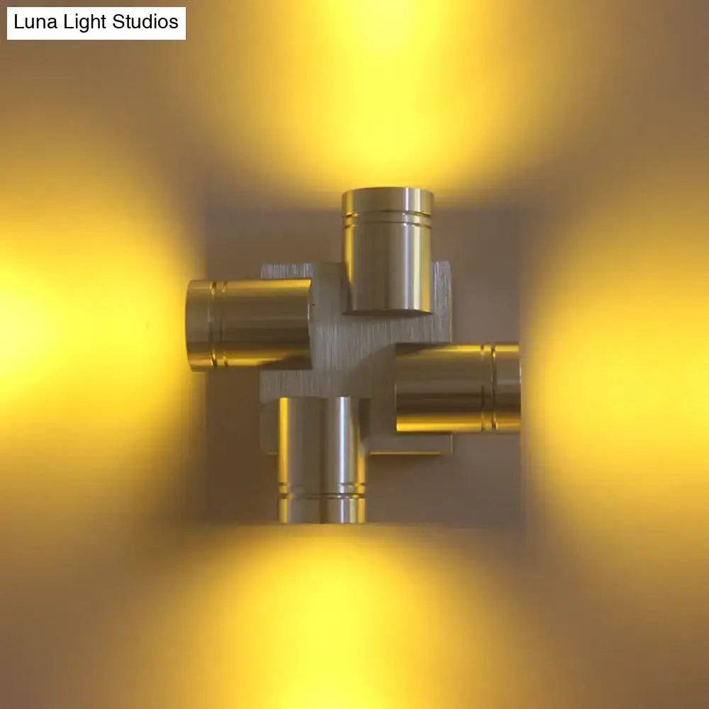 Modern brushed gold cross aluminum wall mount lamp emitting warm yellow light for bedroom use with silver brushed finish