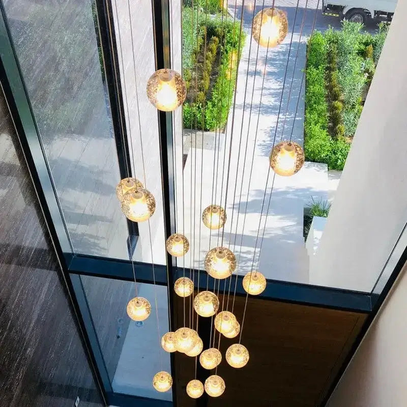 Modern crystal ball led chandelier with multiple warm golden glass orbs suspended by thin cables for living room decorbites crystal ball