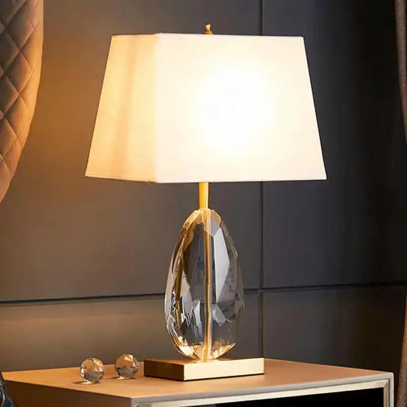 Modern crystal bedside lamp with decorbites crystal base gold metal accents and white fabric shade for bedroom lighting