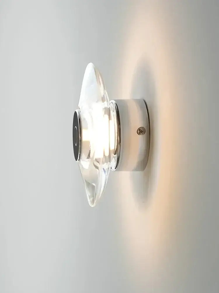 Modern crystal bedside wall lamp with clear glass sconce, sleek chrome base, and black circular accent for bedroom decorbites