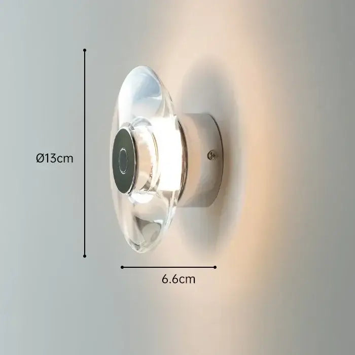 A sleek modern wall lamp with clear glass dome and polished chrome base for decorbites crystal bedside wall lighting