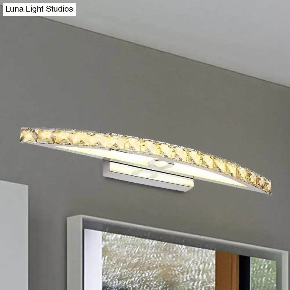 Curved LED bathroom mirror light with sleek chrome finish and clear champagne embedded crystal accents emitting warm glow