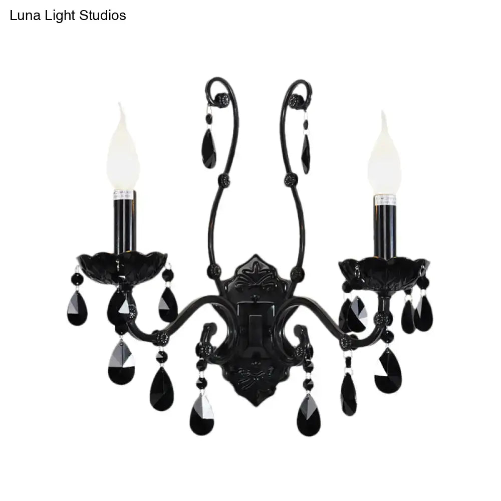 Elegant black wrought iron modern crystal cone wall mount sconce with two candle-style bulbs and teardrop accents