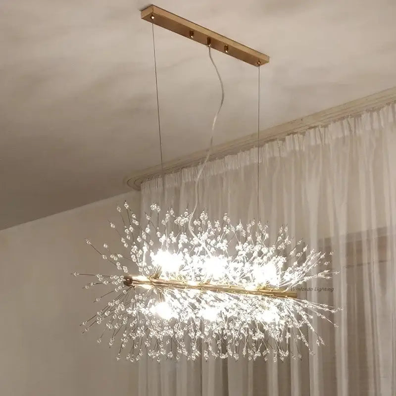 A modern gold-toned decorbites dandelion chandelier led pendant lamp with clear crystal strands for dining room decor