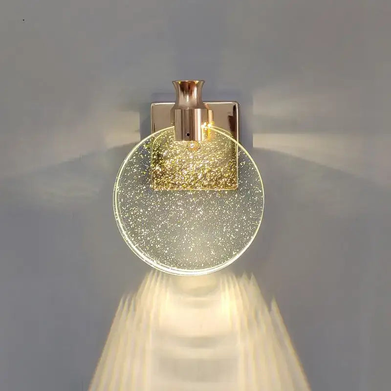 Gold-toned wall lamp with decorbites crystal glass shade and square metallic base for modern bedroom sconce decor