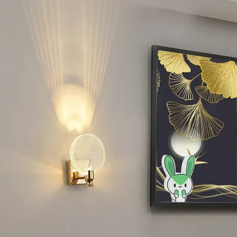 Modern crystal glass gold wall lamp bedroom sconce with gold-toned base and textured circular glass shade emitting warm light