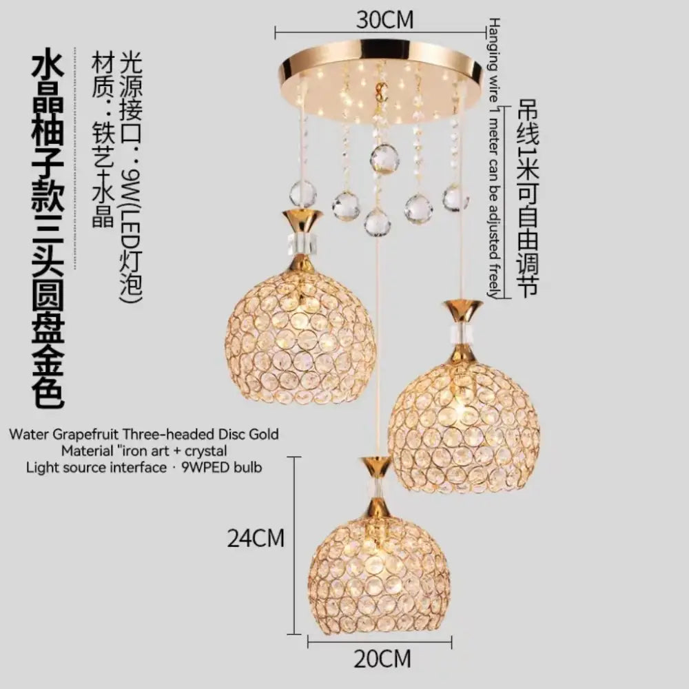 Modern crystal gold ceiling chandelier with three gold-toned heads, faceted glass orbs, and dangling clear crystals