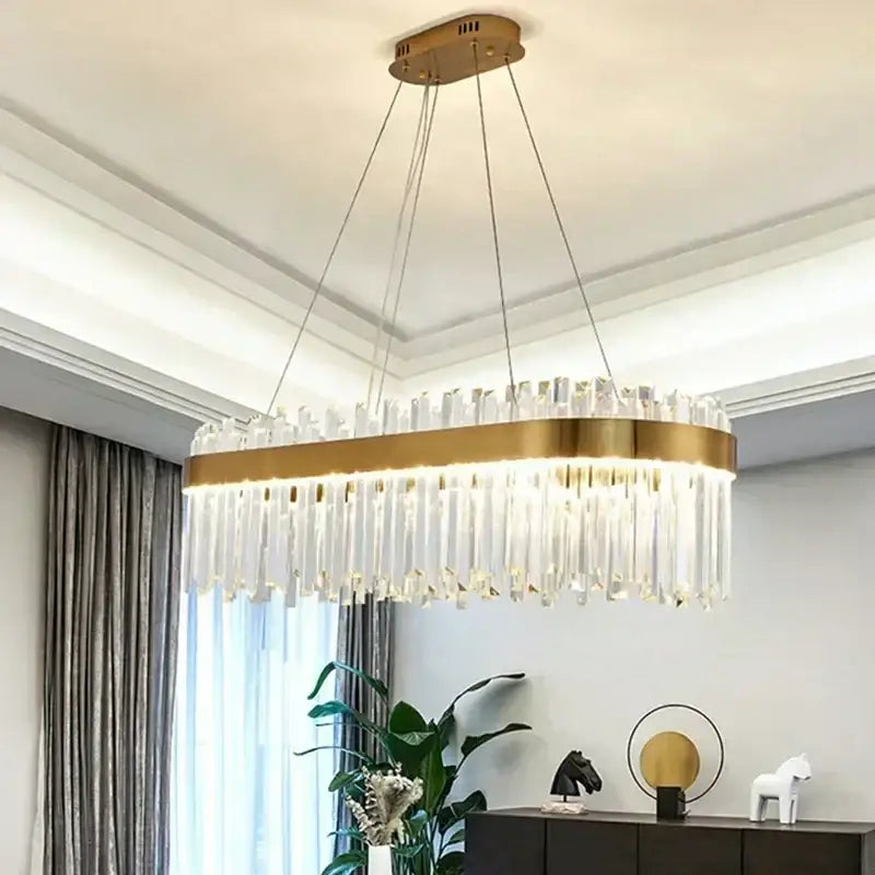 Modern crystal gold ceiling pendant light featuring a gold-toned oval chandelier with clear crystal prisms by decorbites crystal gold