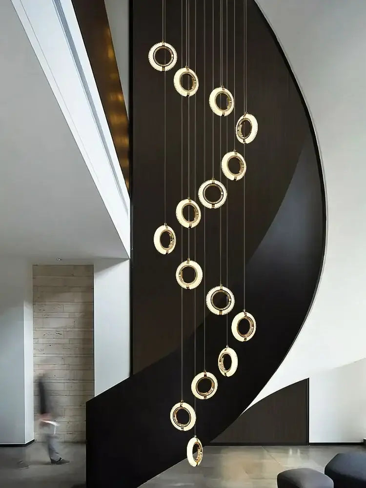 A modern crystal gold led chandelier with minimalist circular rings suspended by thin cables for dining room decorbites