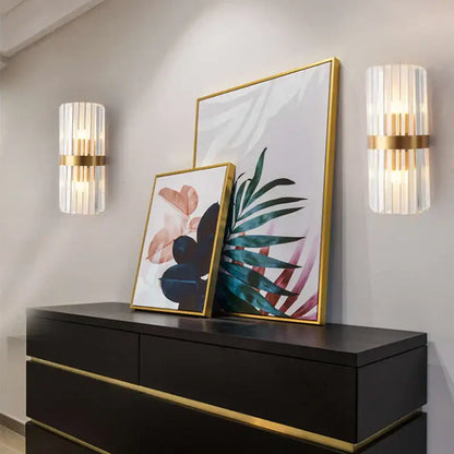 Gold-framed botanical artwork with abstract teal pink and black motifs complements modern crystal gold led wall sconce decorbites