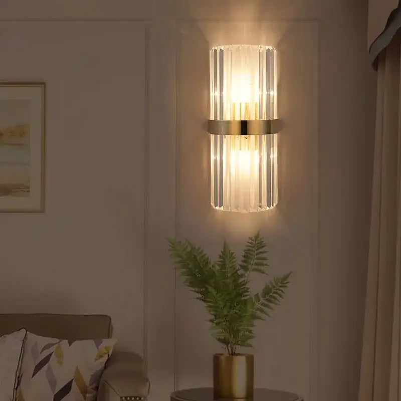 Modern crystal gold led wall sconce with cylindrical glass rod design and polished gold-toned metal band decorbites crystal gold