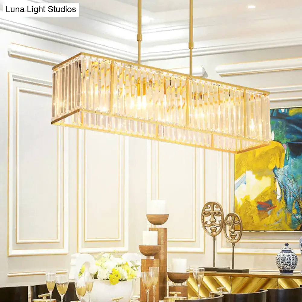 Gold-toned modern restaurant pendant island light with black and gold rectangle shade and vertical crystal rods
