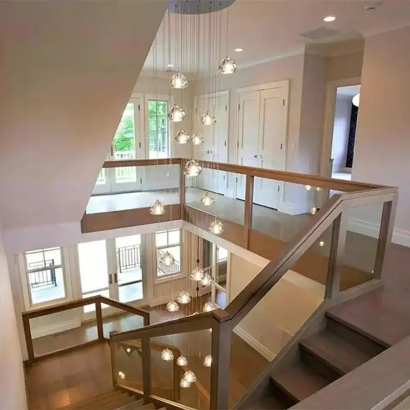 Modern glass and wood staircase with decorbites crystal led ceiling chandelier featuring clear spherical glass globes