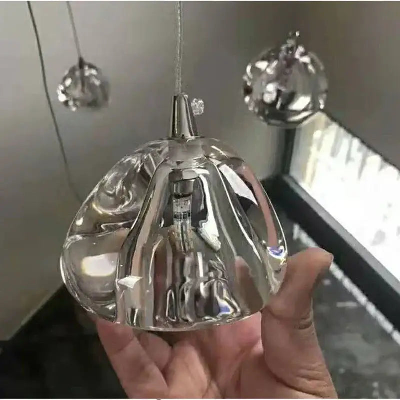 A modern crystal led ceiling chandelier featuring a transparent glass globe pendant with polished metallic stem decorbites crystal led