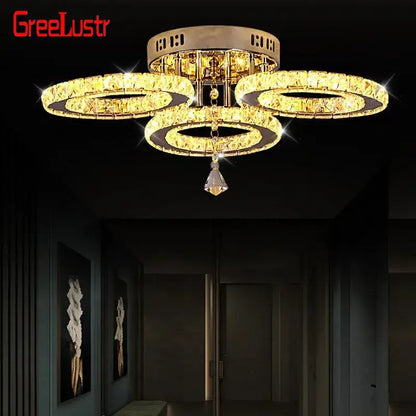 Modern gold-toned crystal led ceiling light with three interlocking rings and a faceted pendant for living room use