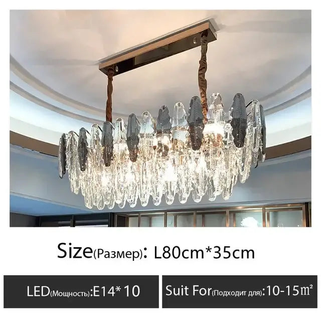 A modern crystal led chandelier with brass ceiling mount and twisted bronze chains suspending clear and dark gray prisms