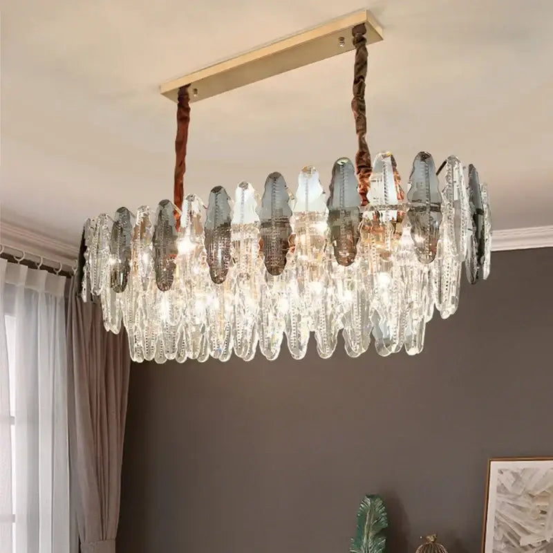A modern decorbites crystal led chandelier with cascading clear and frosted glass teardrop prisms in gold frame