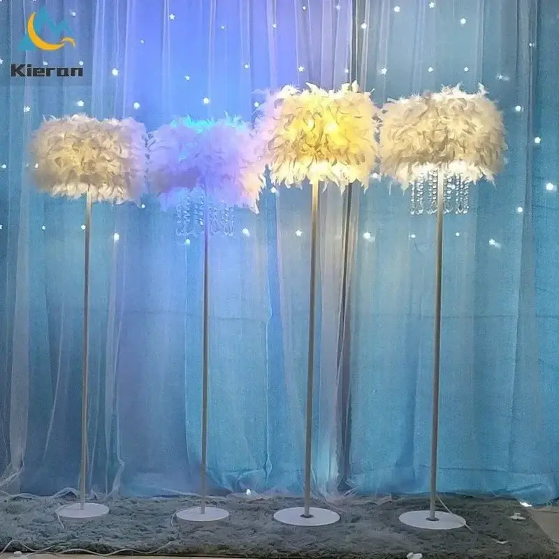 Four elegant modern crystal led feather floor lamps with white and pale yellow plumage on metallic poles for living room decor