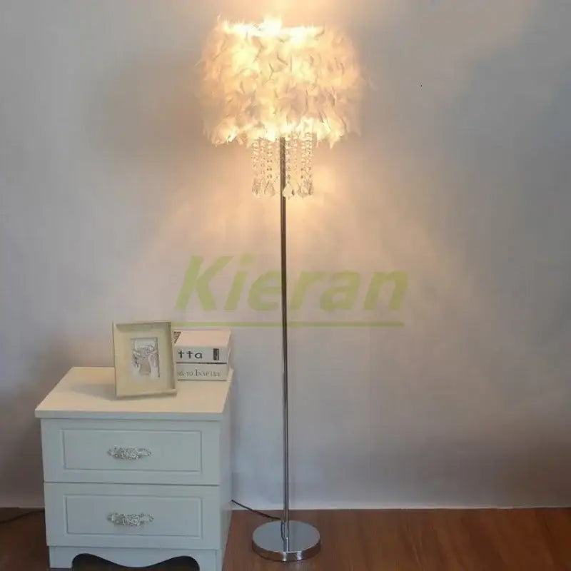 A tall slender floor lamp with white feathered shade and dangling crystal accents decorbites crystal led feather design