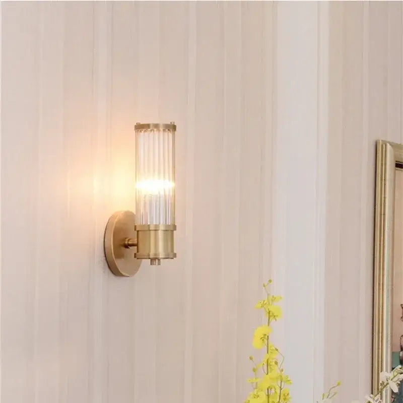 Modern crystal led gold wall sconce with a gold-toned cylindrical glass shade featuring vertical ridges for bedroom decorbites crystal led lighting