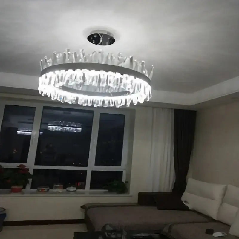 A modern crystal led ring chandelier with a sleek chrome frame and dangling glass elements for luxury decorbites lighting