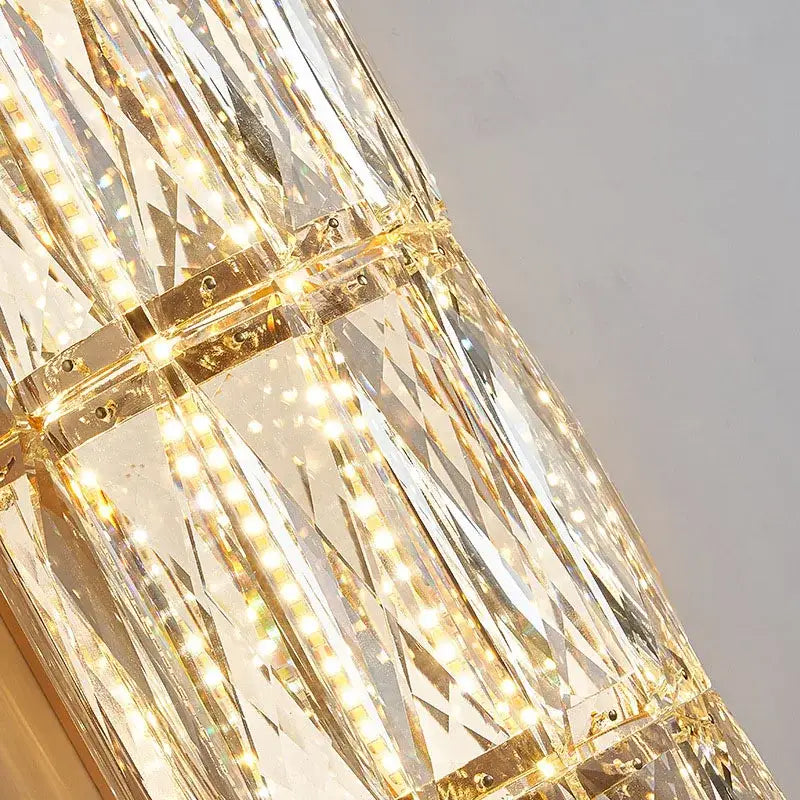 Modern crystal led wall lamp with faceted glass panels and gold metal accents illuminated by warm led lights decorbites crystal led wall lamp