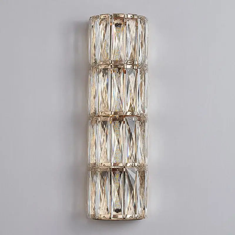 A modern crystal led wall lamp with three stacked tiers of faceted crystals in polished gold-toned metal for living room decorbites crystal led wall