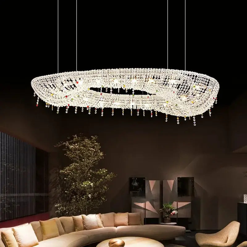 A modern decorbites crystal oval chandelier with clear and red crystals suspended by thin wires for living room decor
