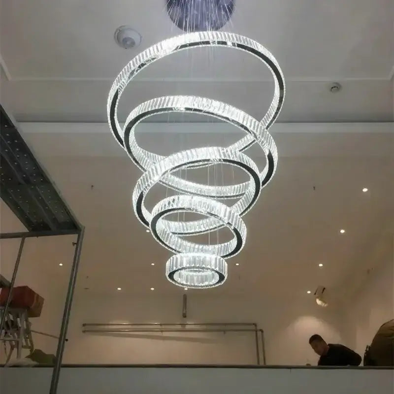 A modern crystal ring led ring led chandelier with concentric spiral rings and clear crystal finish for dining room decorbites