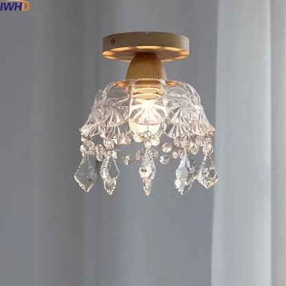 A modern decorbites crystal wood led ceiling lamp with clear teardrop crystals and a wooden base for bedroom decor