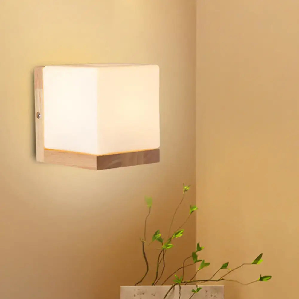 Modern cube shaped sconce wall lamp with frosted white diffuser and wooden backplate for bedroom lighting
