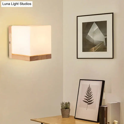 Modern cube shaped sconce wall lamp with frosted glass and wooden backplate for bedroom lighting