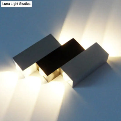 Modern cubic silver and black wall sconce with three matte rectangular panels for direct wired electric porch use