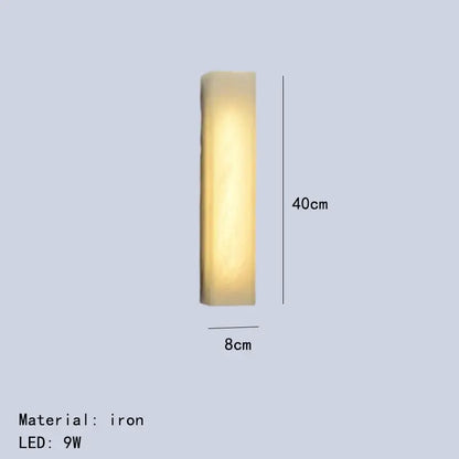 A sleek 40cm tall iron wall lamp with warm yellow glow from decorbites cuboid marble led collection for bedroom lighting