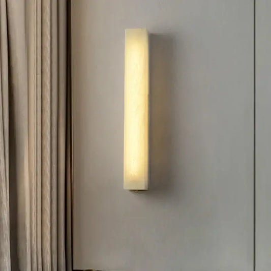 A sleek off-white cuboid marble led wall lamp with warm diffused glow for bedroom dimmable lighting decorbites cuboid marble