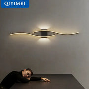 Modern curved gold led wall lamp with sleek design and black rectangular base for stylish bedroom lighting decorbites led wall