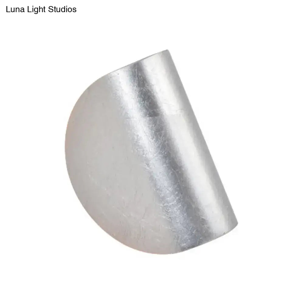 Modern curved gold wall sconce light featuring a silver-toned half-cylinder metal ring with a smooth textured surface