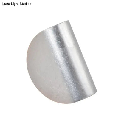 Modern curved gold wall sconce light featuring a silver-toned half-cylinder metal ring with a smooth textured surface